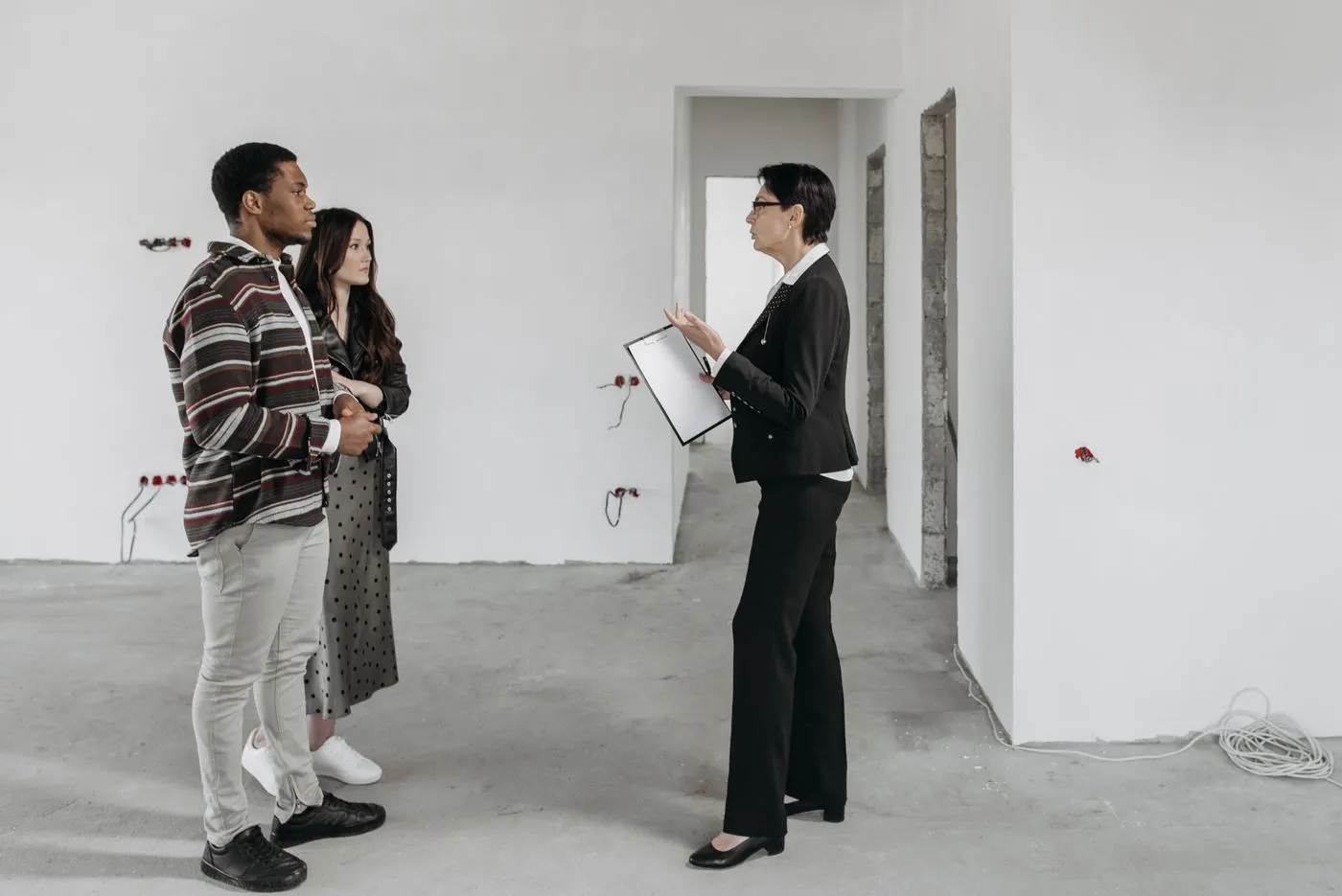 A property manager showing a couple around an empty apartment